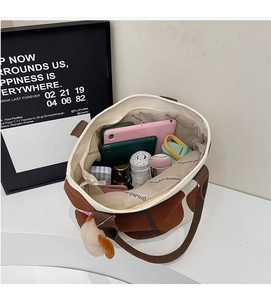 Detailansicht des geräumigen Innenraums der Canvas-Tasche mit Kuhmuster und Alltagsutensilien