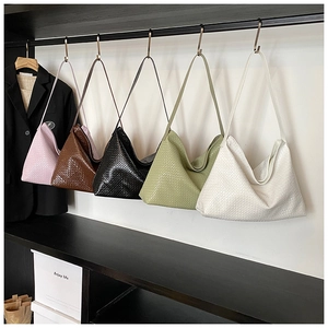 Collection of woven hobo shoulder bags in five colors displayed on a wall rack