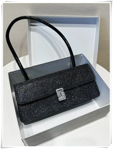 Detailed macro view of black sequined handbag with silver rhinestone S-buckle