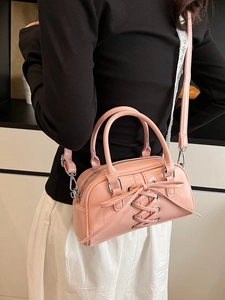 Borsa Boston retrò lucida rosa con lacci e tracolla indossata da una modella