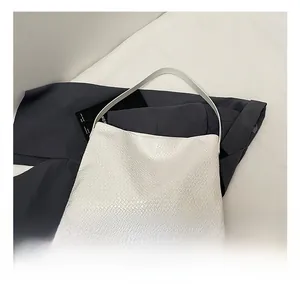 Detail showing the intricate woven leather texture of the pearl white tote shoulder bag
