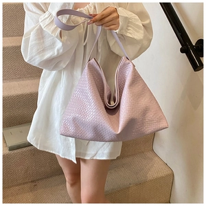 Detail shot of light purple woven tote bag with premium leather texture and wide strap