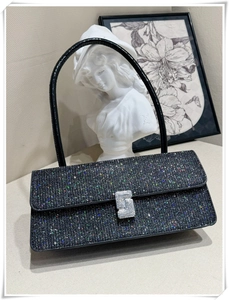 Macro shot of black sequin handbag featuring sparkling glitter and diamond buckle