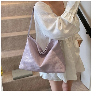 Detailed close-up of light purple woven tote bag with classic intrecciato weave pattern