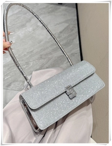 Close-up of silver rhinestone baguette bag featuring a metallic H-shaped buckle clasp