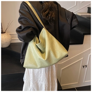 Detail of light green woven tote bag showing the soft texture and large hobo style design