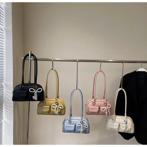 Detail of multi-color leather shoulder bags with pearl bow charms and flap pockets