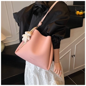 Détail du sac seau rose en cuir grainé avec pendentif ours en peluche doux