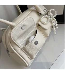 Detail of white lychee leather handbag side pockets showing earbud storage capacity