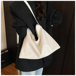 Detail shot of white woven hobo bag with high-quality texture on a model's shoulder