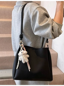 Sac seau minimaliste en cuir grainé noir avec bandoulière et pendentif ours peluche