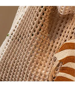 Detail der beigefarbenen Häkel-Netztasche mit gestreifter Stickerei und Strickstruktur