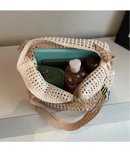 Geräumiges Innere einer beige Häkeltasche mit Tablet, Handy und Pflegeprodukten