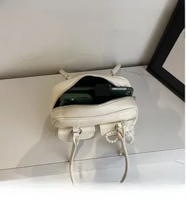 Top view of cream white pebble leather bag showing spacious interior and zip closure