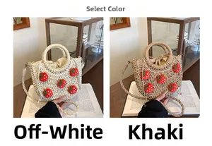 Detail der Strohtasche mit 3D-Erdbeer-Akzenten und Kordelzug-Innentasche