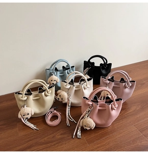 Détail de mini sacs seaux en plusieurs couleurs avec cuir grainé litchi et breloques nounours