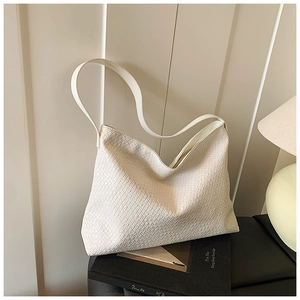 Detail of off-white woven hobo bag showing intricate checkerboard weave and soft leather texture
