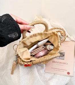 Geräumiges Innenfach der Stroh-Handtasche mit Kosmetika und Alltagsgegenständen im Detail