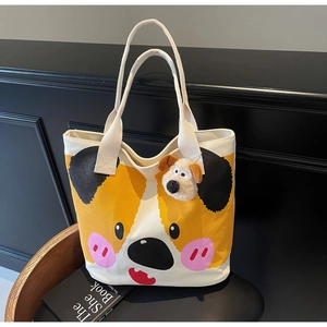 Nahaufnahme von Cartoon-Hunde-Print auf Canvas-Tote-Bag mit süßem Plüsch-Anhänger