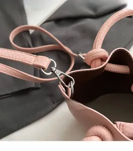 Détail du sac seau en cuir rose à grain litchi avec crochet métallique argenté poli