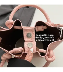 Gros plan du sac seau en cuir rose avec fermeture magnétique et texture grainée