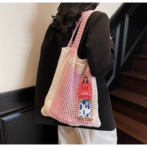 Detail der rosa-beige gewebten Netztasche mit Cartoon-Stickerei an der Schulter