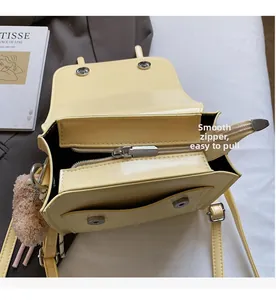 Detail of smooth metal zipper and multi-layer interior compartments of the yellow crossbody bag