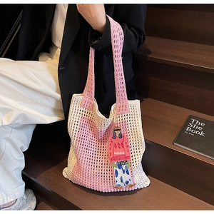 Nahaufnahme der Stricktasche mit hohlmaschigem Design und Stickerei auf einer Treppe