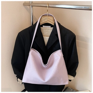 Detail of lavender woven tote bag hung on a hanger with a black suit blazer