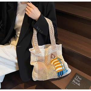 Detailaufnahme der Häkel-Tote-Bag mit Cartoon-Patchwork auf creme-gewebter Netzstruktur