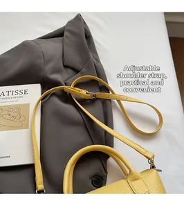 Vue détaillée de la bandoulière en cuir réglable avec boucle argentée sur un sac jaune