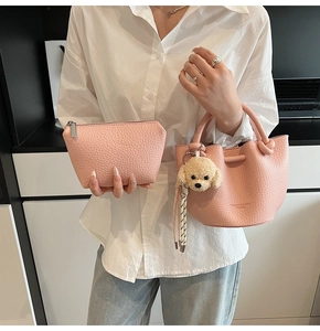 Pink bucket bag and zipper pouch set with cute plush puppy charm on a model