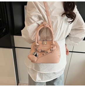 Vue détaillée du sac en cuir verni rose avec chaîne métallique et pendentif en cœur