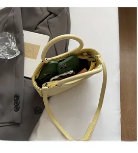 Detailed internal view of pale yellow bucket bag showing large capacity and zipper pocket
