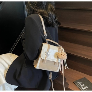 Detailed view of bicolor backpack with star metal buckle and plush bear charm