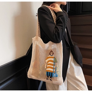Detail der gehäkelten Tragetasche mit Cartoon-Mädchen-Patch und hohler Netzstruktur