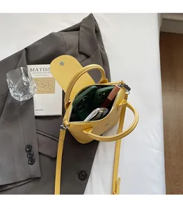 Vue intérieure du sac à main jaune grainé montrant la capacité pour téléphones et maquillage