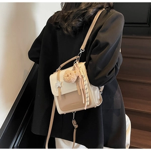 Detail of crossbody bag with star buckle, plush bear charm and adjustable strap