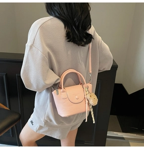 Détail d'un sac à main rose en cuir grainé avec charm ours et petit foulard en soie