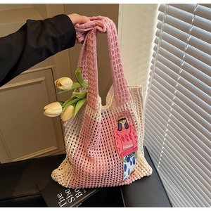 Detail der gehäkelten Handtasche mit rosa Stickerei und Cartoon-Patch im Shopper-Stil