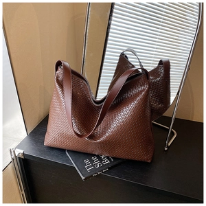 Detail of dark brown woven tote bag featuring high-quality Intrecciato leather craftsmanship