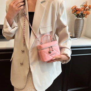 Pink quilted leather vanity bag with heart charm and woven chain strap detail