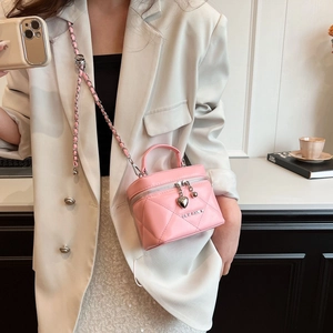 Detail of pink quilted leather mini box bag with chain strap and heart charm