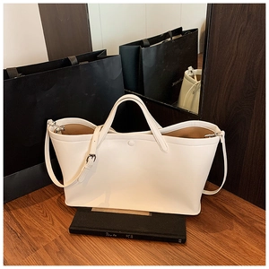 Detail of cream leather tote bag with round handle and adjustable shoulder strap