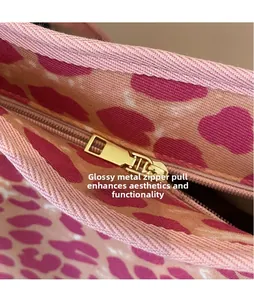 Close-up of sleek golden metal zipper pull on a leopard print canvas bucket bag