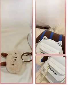 Détail d'un sac bandoulière en toile blanche avec oreilles de chat et pendentif peluche