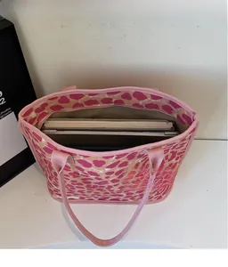 Detail of pink leopard print tote bag interior showing spacious capacity for laptops