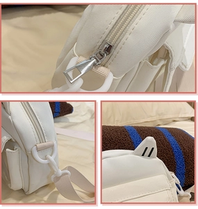 Détails d'un sac bandoulière en nylon blanc avec zips argentés et décorations mignonnes