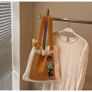 Detail der Stricktasche mit gelbem Netzmuster, Cartoon-Stickerei und Dekoration