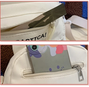 Détail montrant la fermeture éclair en métal et le compartiment de ce sac en toile blanc